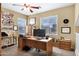 Office space with wooden desk, office chair, and natural light from three windows at 2280 E Aloe Pl, Chandler, AZ 85286