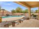 Resort-style pool with a stone waterfall feature surrounded by well-manicured landscaping and desert scenery at 2280 E Aloe Pl, Chandler, AZ 85286
