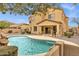 Backyard view of sparkling pool with rock waterfall, surrounded by patio and lush landscaping at 2280 E Aloe Pl, Chandler, AZ 85286