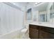 Bright bathroom featuring a shower with a white curtain, white fixtures, and dark wood cabinets at 2315 N 73Rd Dr, Phoenix, AZ 85035