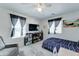 Bright bedroom featuring a TV, ceiling fan, windows, a bed, and comfortable furnishings at 2315 N 73Rd Dr, Phoenix, AZ 85035