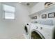 Neat laundry room equipped with modern appliances, shelving, a window, and stylish decor at 2315 N 73Rd Dr, Phoenix, AZ 85035