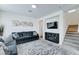 Cozy living room featuring a sectional sofa, patterned rug, fireplace, and stairs to the next level at 2315 N 73Rd Dr, Phoenix, AZ 85035