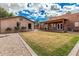 Spacious backyard featuring a grassy area, shed, covered patio, gravel landscaping, and a blue sky above at 26015 S Grapefruit Dr, Queen Creek, AZ 85142