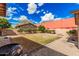 An outdoor living space with a grill, gravel, fire pit, and views of a detached garage and blue skies at 26015 S Grapefruit Dr, Queen Creek, AZ 85142