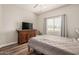 Bedroom featuring a large window, dresser, and hardwood floors; the bed is neatly covered with a gray comforter at 26015 S Grapefruit Dr, Queen Creek, AZ 85142
