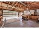 A spacious two car garage with an open garage door, cabinets, a lawn mower and a work bench at 26015 S Grapefruit Dr, Queen Creek, AZ 85142