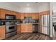 Well-lit kitchen with stainless steel appliances, wooden cabinets, and mosaic backsplash at 26015 S Grapefruit Dr, Queen Creek, AZ 85142