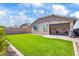 Landscaped backyard featuring green lawn, shaded patio, and privacy fence at 4121 W Bradshaw Creek Ln, New River, AZ 85087
