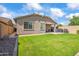 Green backyard featuring lush lawn, a patio with outdoor seating, and block fence at 4121 W Bradshaw Creek Ln, New River, AZ 85087