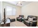 Cozy bedroom with two black leather chairs, a ceiling fan, and a window at 4121 W Bradshaw Creek Ln, New River, AZ 85087