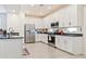 Modern kitchen featuring stainless steel appliances, white cabinetry, and tile flooring at 4121 W Bradshaw Creek Ln, New River, AZ 85087