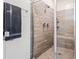 Modern shower stall with glass doors, tiled walls, and a rainfall shower head at 4121 W Bradshaw Creek Ln, New River, AZ 85087
