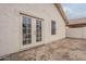 Exterior view of the home with a backyard featuring french doors and a small window on a textured stucco wall at 4545 N 67Th Ave # 1106, Phoenix, AZ 85033