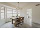 Bright dining area featuring a rustic wood table, stylish chandelier, and large windows at 4545 N 67Th Ave # 1106, Phoenix, AZ 85033