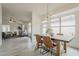 Open-concept dining area with wood floors, a rustic table, and seamless flow to the living room at 4545 N 67Th Ave # 1106, Phoenix, AZ 85033