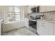 Updated kitchen with white cabinets, stainless steel appliances, and an arched window overlooking the yard at 4545 N 67Th Ave # 1106, Phoenix, AZ 85033