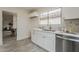This renovated kitchen has white cabinets, gold hardware, stainless appliances and wood-look flooring at 4545 N 67Th Ave # 1106, Phoenix, AZ 85033