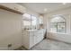Bright kitchen features white cabinets, gold hardware, and a large arched window with neighborhood views at 4545 N 67Th Ave # 1106, Phoenix, AZ 85033