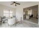 Open-concept living room with grey chairs, ceiling fan, and plenty of natural light at 4545 N 67Th Ave # 1106, Phoenix, AZ 85033