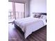 Relaxing bedroom with balcony access featuring modern bed and wood floors at 4750 N Central Ave # 3B, Phoenix, AZ 85012
