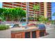Outdoor kitchen area with built-in grill, sink, and counter space, set against a backdrop of palm trees and the building at 4750 N Central Ave # 3B, Phoenix, AZ 85012