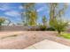 Spacious backyard with gravel landscaping, a block wall, and mature trees at 4831 N 93Rd Dr, Phoenix, AZ 85037