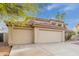 Beige two-story home with a red tile roof and spacious three-car garage on concrete driveway at 4831 N 93Rd Dr, Phoenix, AZ 85037