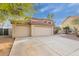 Beige two-story home with a red tile roof and spacious three-car garage on concrete driveway at 4831 N 93Rd Dr, Phoenix, AZ 85037