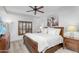 Bedroom with a wooden sleigh bed, ceiling fan, window with shutters, and painting of horses on the wall at 5350 E Deer Valley Dr # 1419, Phoenix, AZ 85054