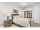Bedroom featuring a neutral color scheme, wooden bed frame, side table, and window with shutters at 5350 E Deer Valley Dr # 1419, Phoenix, AZ 85054