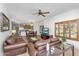 Open living area with a leather sofa set, ceiling fan, TV, kitchen in background and lots of natural light at 5350 E Deer Valley Dr # 1419, Phoenix, AZ 85054