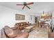 Open living area with a leather sofa set, ceiling fan, art on the wall, kitchen in background and tile floors at 5350 E Deer Valley Dr # 1419, Phoenix, AZ 85054