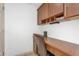Office space featuring a built-in desk with storage, overhead cabinets, a leather office chair and tile floors at 5350 E Deer Valley Dr # 1419, Phoenix, AZ 85054