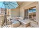 Outdoor patio with neutral colored patio furniture, shade umbrella, stone wall and tile flooring at 5350 E Deer Valley Dr # 1419, Phoenix, AZ 85054