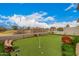 Private backyard putting green bordered by stone landscaping, providing a tranquil setting for outdoor recreation at 606 S 124Th Ave, Avondale, AZ 85323