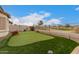 This backyard offers a private putting green, low-maintenance landscaping, and views of the community at 606 S 124Th Ave, Avondale, AZ 85323