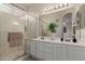 Bathroom features a double sink vanity, a glass-enclosed shower, and neutral decor at 606 S 124Th Ave, Avondale, AZ 85323