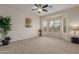 Spacious bedroom with large windows, plush carpet, and a ceiling fan at 606 S 124Th Ave, Avondale, AZ 85323