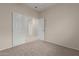 Carpeted bedroom featuring open, bi-fold doors leading to additional rooms beyond at 606 S 124Th Ave, Avondale, AZ 85323