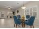 Cozy dining area featuring a glass table, modern light fixture, and neutral tones at 606 S 124Th Ave, Avondale, AZ 85323
