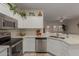 Kitchen features white cabinetry, stainless appliances, and a view of the dining area at 606 S 124Th Ave, Avondale, AZ 85323