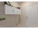 Laundry room with white cabinets, tile floors, and white door at 606 S 124Th Ave, Avondale, AZ 85323