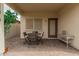 Covered patio featuring brick pavers, complemented by a table and chairs, offers a cozy outdoor retreat at 606 S 124Th Ave, Avondale, AZ 85323