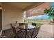Relaxing covered patio boasts a table and chairs perfect for outdoor dining with a golf course view at 606 S 124Th Ave, Avondale, AZ 85323