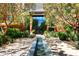 Building entrance with water feature, lush landscaping, and flowers at 6166 N Scottsdale Rd # C4004, Paradise Valley, AZ 85253