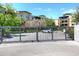 Electronic security gate, lush landscaping and exterior view of the building at 6166 N Scottsdale Rd # C4004, Paradise Valley, AZ 85253