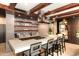 Modern kitchen with a stone island, overhead lighting, bar stool seating, and premium appliances at 6166 N Scottsdale Rd # C4004, Paradise Valley, AZ 85253