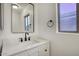 Half bath featuring large mirror, modern fixtures, and a white vanity at 6608 W Whispering Wind Dr, Glendale, AZ 85310