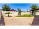 Spacious backyard featuring gravel, green grass, block fence, and a covered patio area at 7056 W Caron Dr, Peoria, AZ 85345